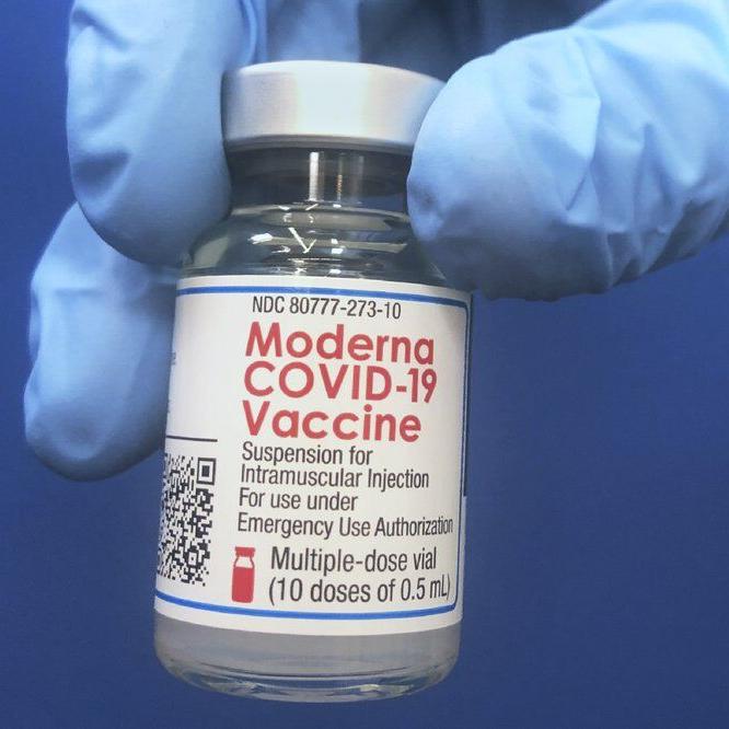 Vial of Moderna COVID-19 vaccine being held.jpeg